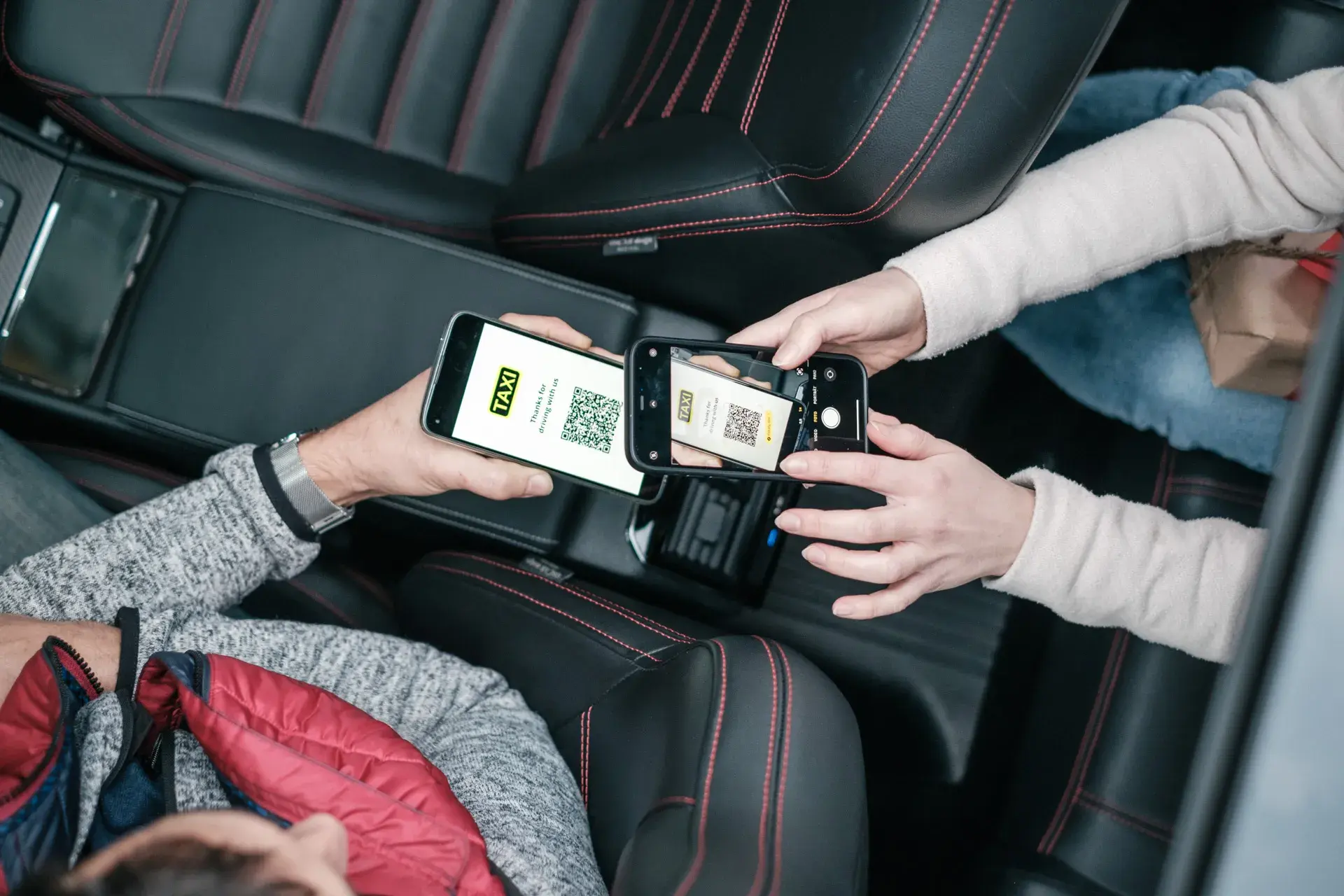 Woman in a taxi scanning a QR code to receive a fiskaly digital receipt
