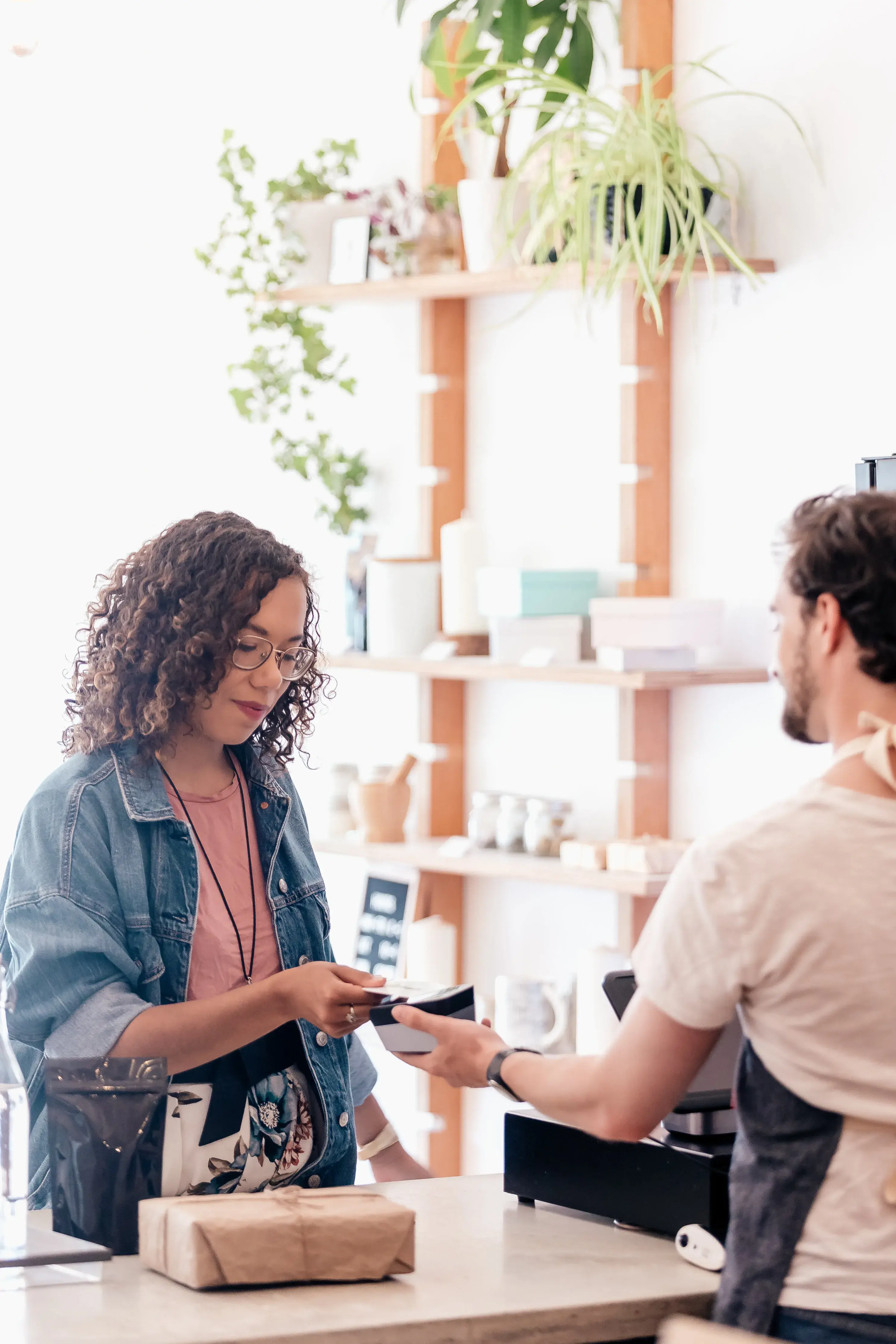 Woman pays in a shop for her purchase with her phone to POS system
