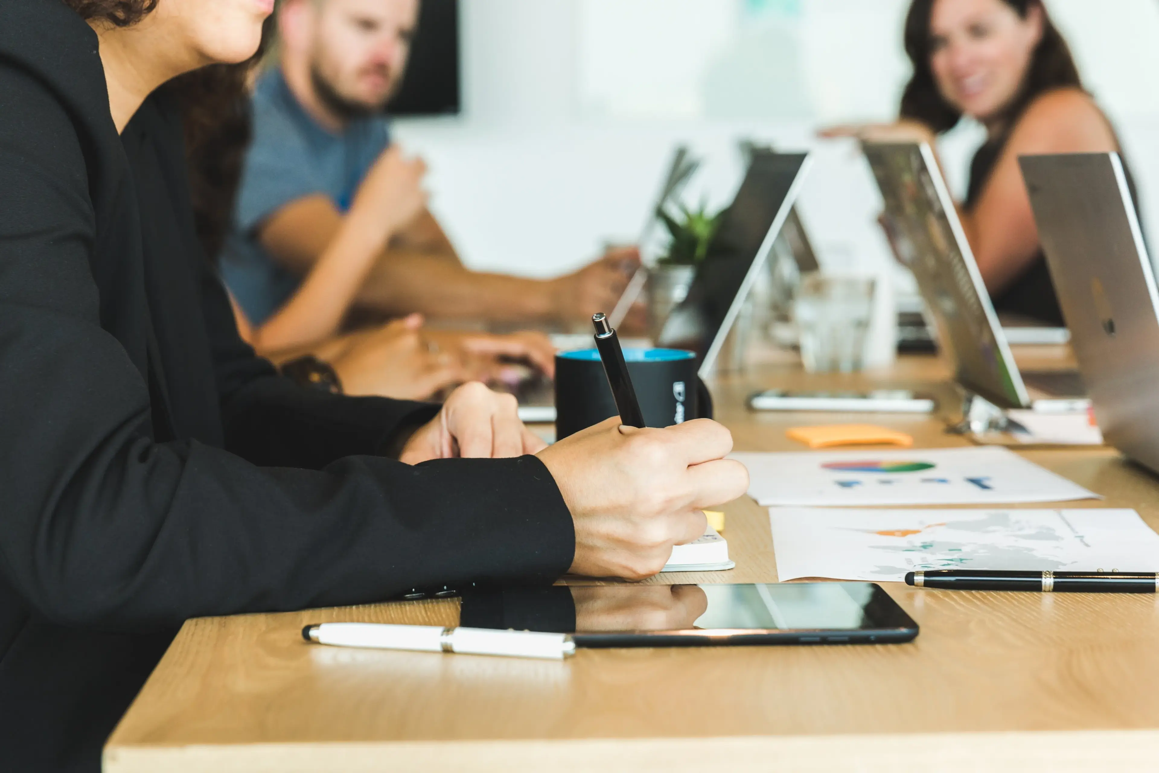 People sit at a table with computers in front of them
